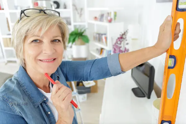 stock image senior female construction holding level