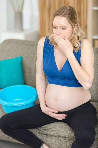 ソファーに座っている吐き気を持つ若い妊婦 — ストック写真