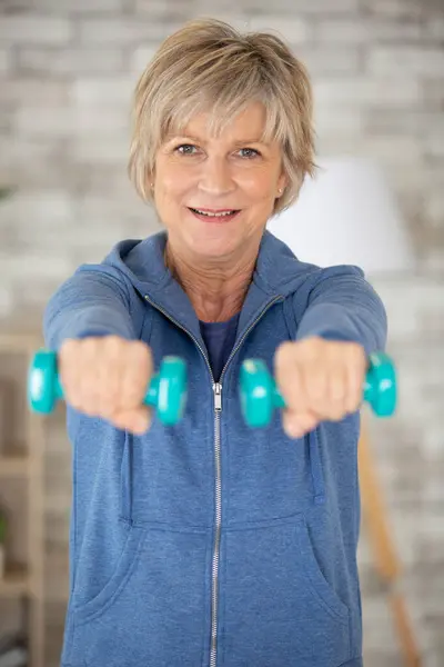 portrait of senior woman lifting dumbbells