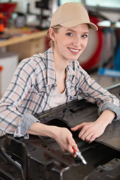 female auto repair worker having a break