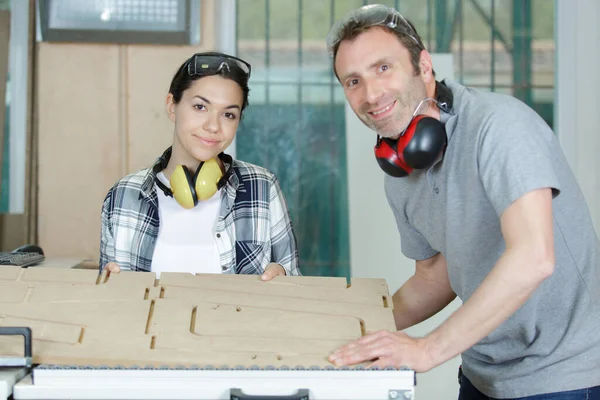 happy man and woman in wood workshop
