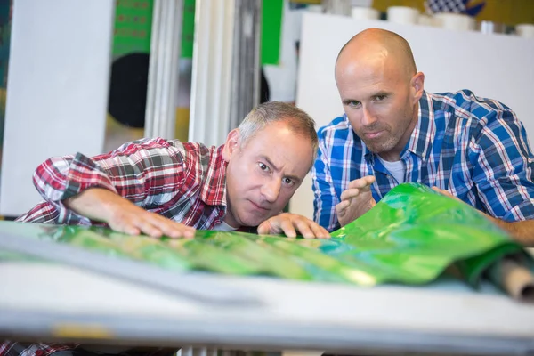 Men Looking Unrolled Green Plastic Material — Stock Photo, Image