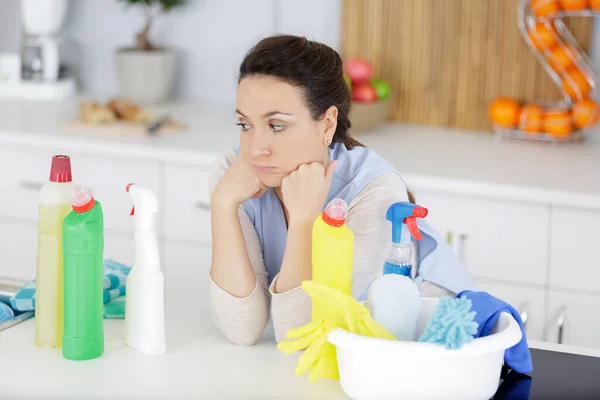 tired woman with cleaning and cleaning products
