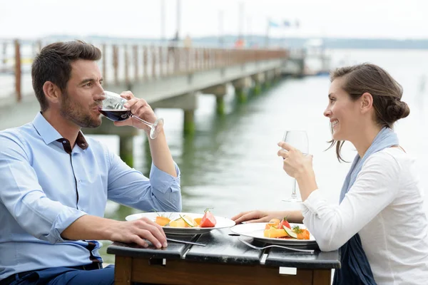 couple on summer vacation drinking wine in sea restaurant