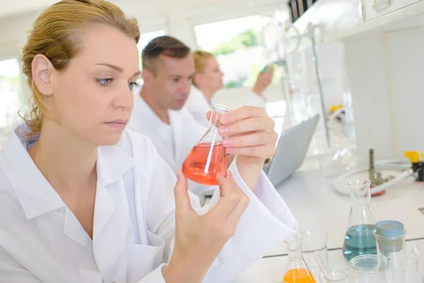 Female lab technician holding glass flask