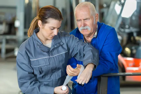 Colleague Wrapping Elderly Workers Hand — Stock Photo, Image