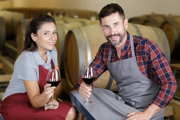 professional team of wine producers posing with wine in cellar