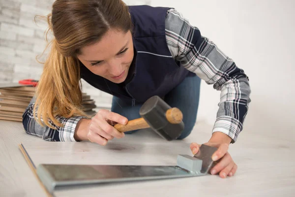 woman installing wood floor