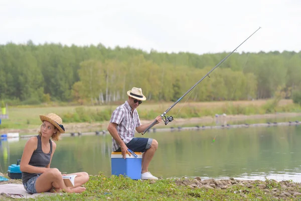 young couple is enjoying fishing on the river