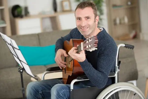 坐在轮椅上玩吉他的快乐男人 — 图库照片
