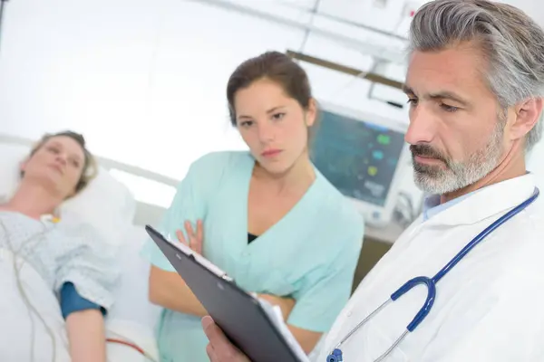 Läkare Och Sjuksköterska Med Urklipp Besöker Patienten — Stockfoto