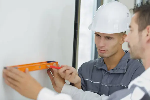 Teenage Apprentices Leveling Wall Stock Image