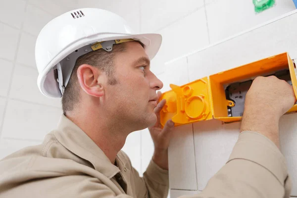 electrician installing wall power socket