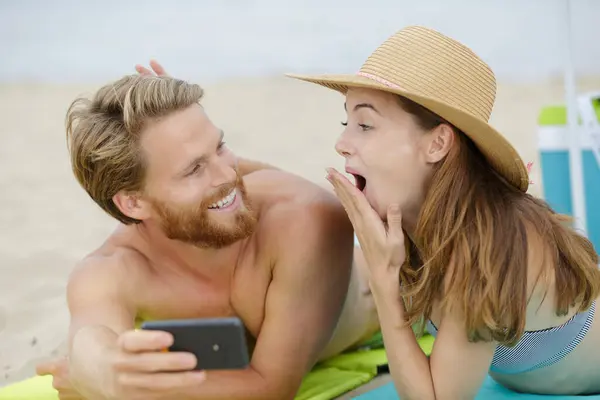 Paar Het Strand Kijken Geschokt Smartphone Inhoud — Stockfoto