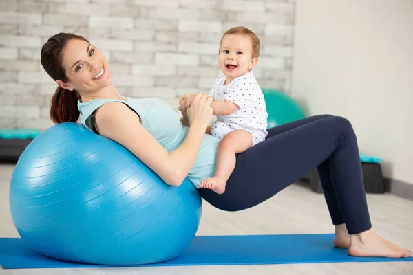 Egzersiz Topu Olan Mutlu Genç Bir Anne Eğleniyor — Stok fotoğraf