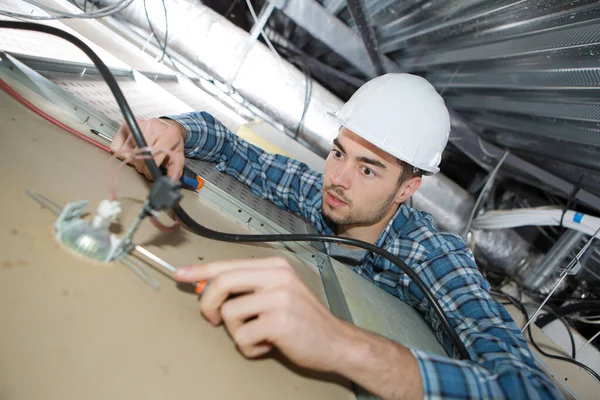 portrait of electrician repairing ceiling light
