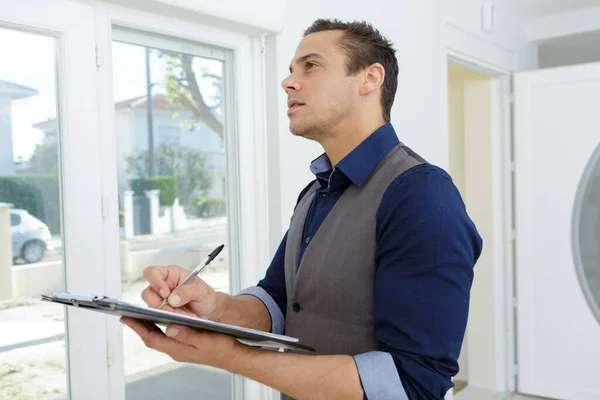 Male Estate Agent Visiting Property Making Notes — Stock Photo, Image