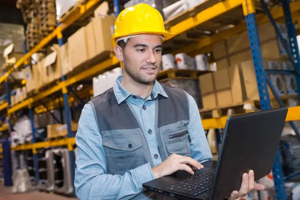 portrait of worker in warehouse with laptop computer