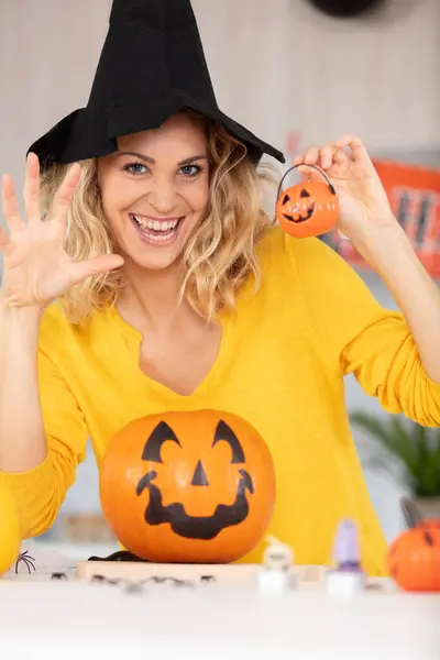 excited woman with pumpkin decorations for halloween