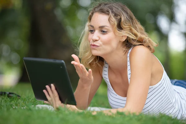 young woman with tablet on the grass