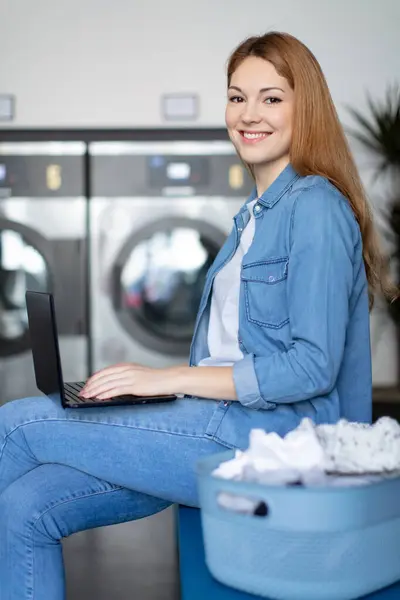 Pěkná Žena Dělá Prádelna Při Práci Notebooku — Stock fotografie