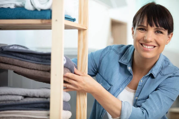 smiling woman order the linens in the closet