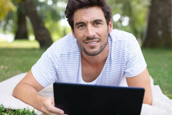 handsome man working on computer in nature