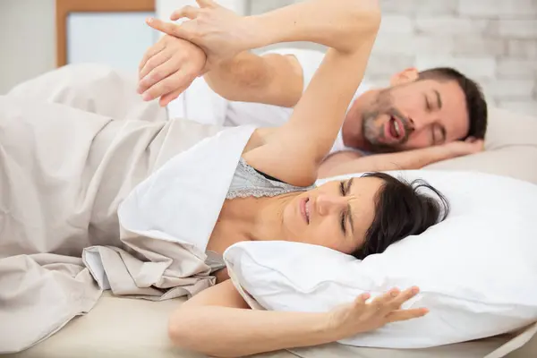 snoring husband annoys wife in bed
