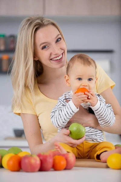 Joven Madre Sonriendo Sosteniendo Bebé Cocina — Foto de Stock