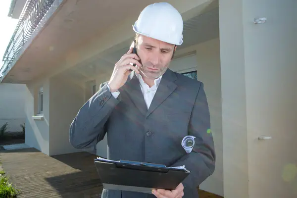 portrait man engineer in black suit using a smart phone