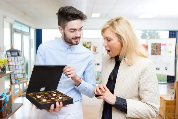 Viser Eske Med Assortert Sjokolade Til Klienten – stockfoto