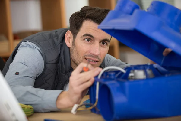 Man Inspecting Blue Plastic Box Housing Electrical Component — Stock Photo, Image