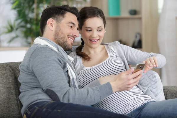Hombre Feliz Con Mujer Embarazada Sofá —  Fotos de Stock