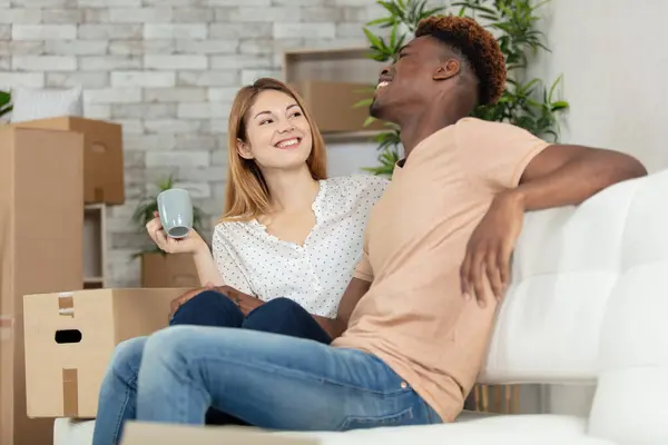 happy couple relaxing on sofa having fun on moving day