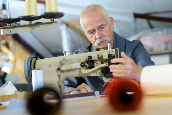 man working on sewing machine