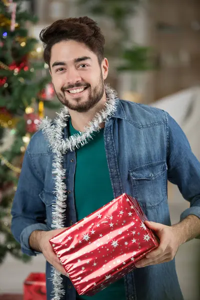 Άνδρας Τυλιγμένος Λινέλα Και Κρατώντας Χριστουγεννιάτικο Δώρο — Φωτογραφία Αρχείου