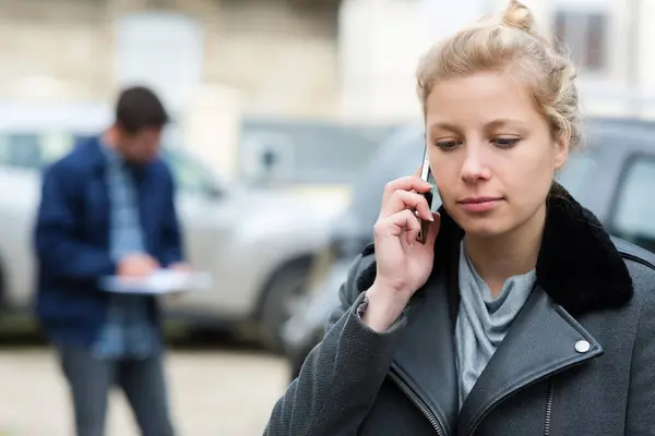 woman dialing her phone after car crash