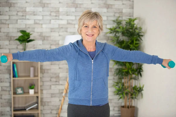 happy senior woman exercising with dumbbell