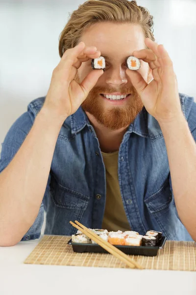 Jovem Cobrindo Seus Olhos Com Rolos Sushi — Fotografia de Stock