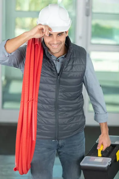 Male Builder Carrying Red Pipe His Shoulder — Stock Photo, Image
