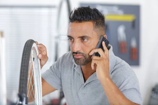 bike mechanic on the phone during bicycle repair