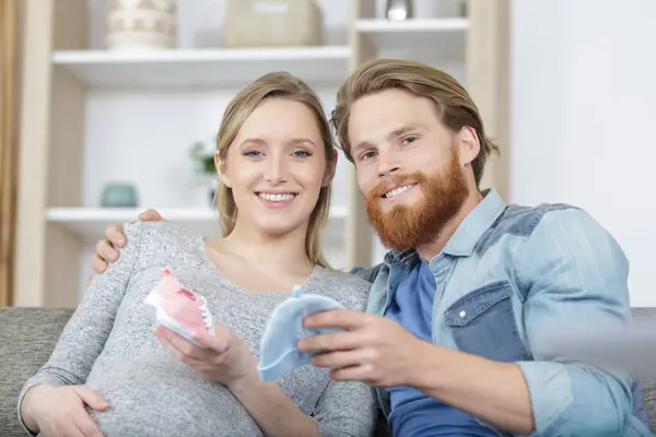 Mann Und Schwangere Frau Betrachten Baby Accessoires — Stockfoto