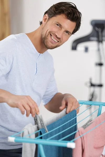 Man Pegging Laundry Airer — Stock Photo, Image