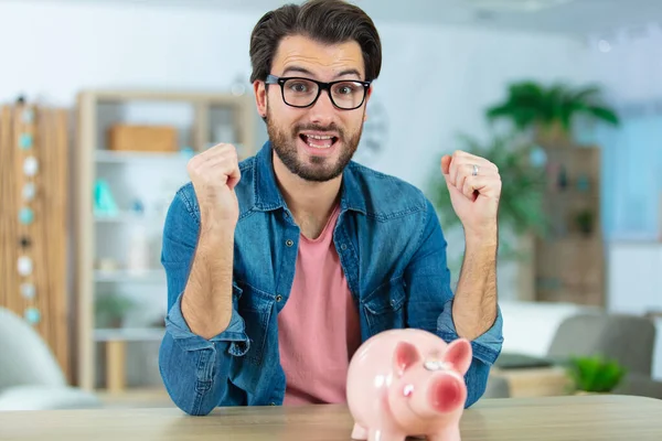 Happy Young Man Putting Money Piggy Bank — Stock Photo, Image