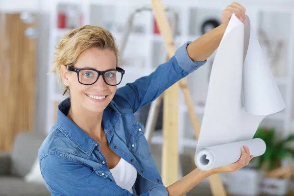 young woman with roll of wallpaper