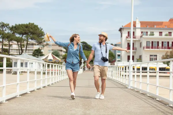 happy young couple walking on a pier on the seashore