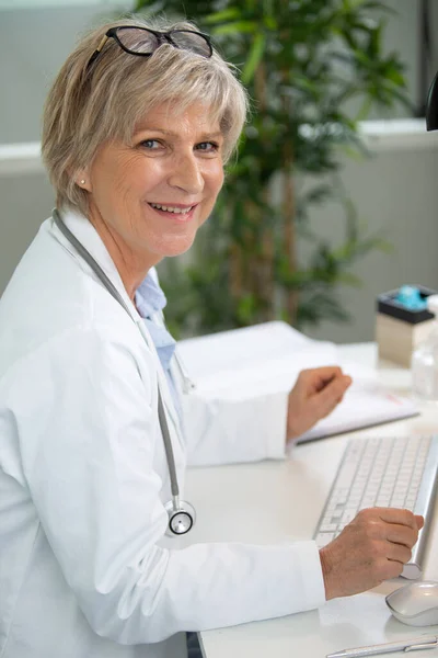 Kadın Doktor Masada Otururken Tıbbi Uzmanlık Üzerinde Çalışıyor — Stok fotoğraf