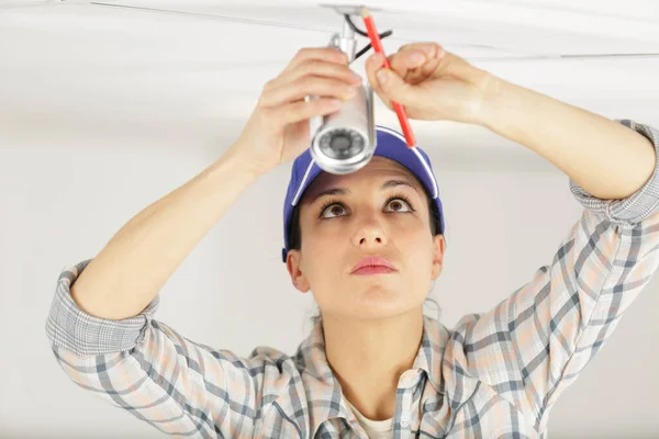 Vrouwelijke Elektricien Installeert Verlichting Plafond — Stockfoto