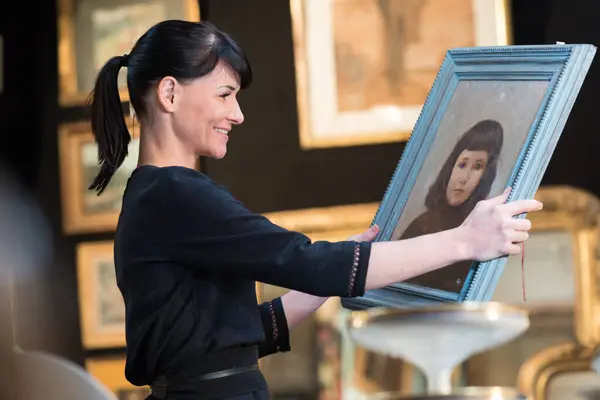 portrait of a woman holding vintage painting