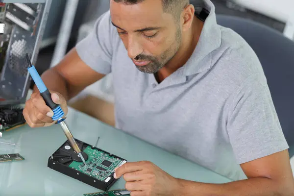 male technician soldering computer component